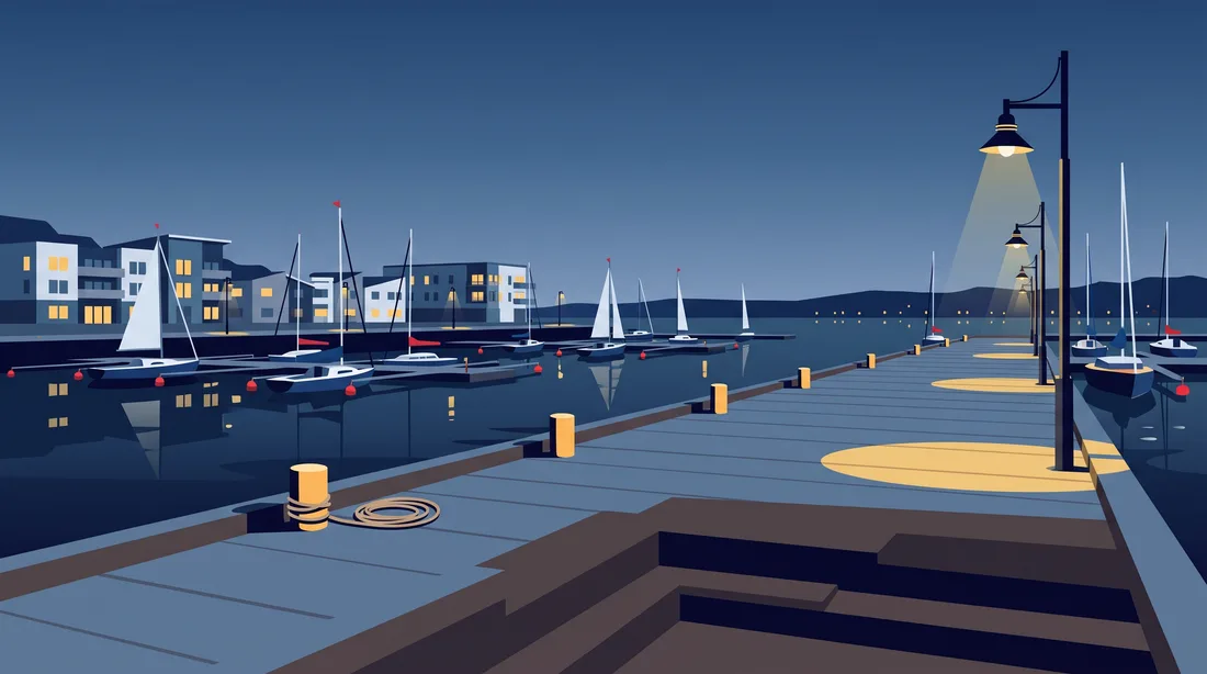 Harbour boardwalk at dusk with lamp posts and moored sailboats